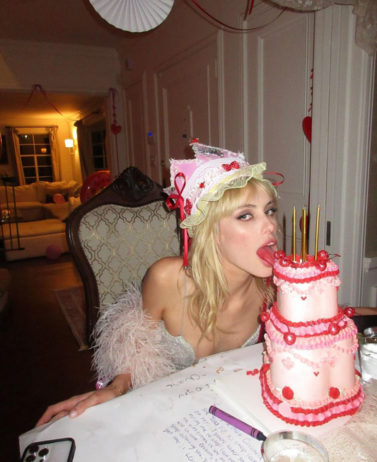 Model in a birthday outfit leaning over a cake with a TikTok interface overlay.